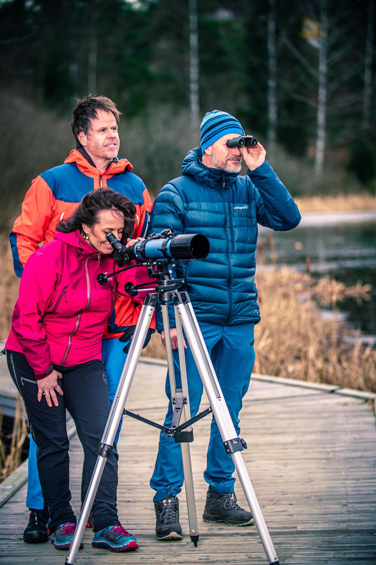 Tre voksne som ser i kikkert - Klikk for stort bilde