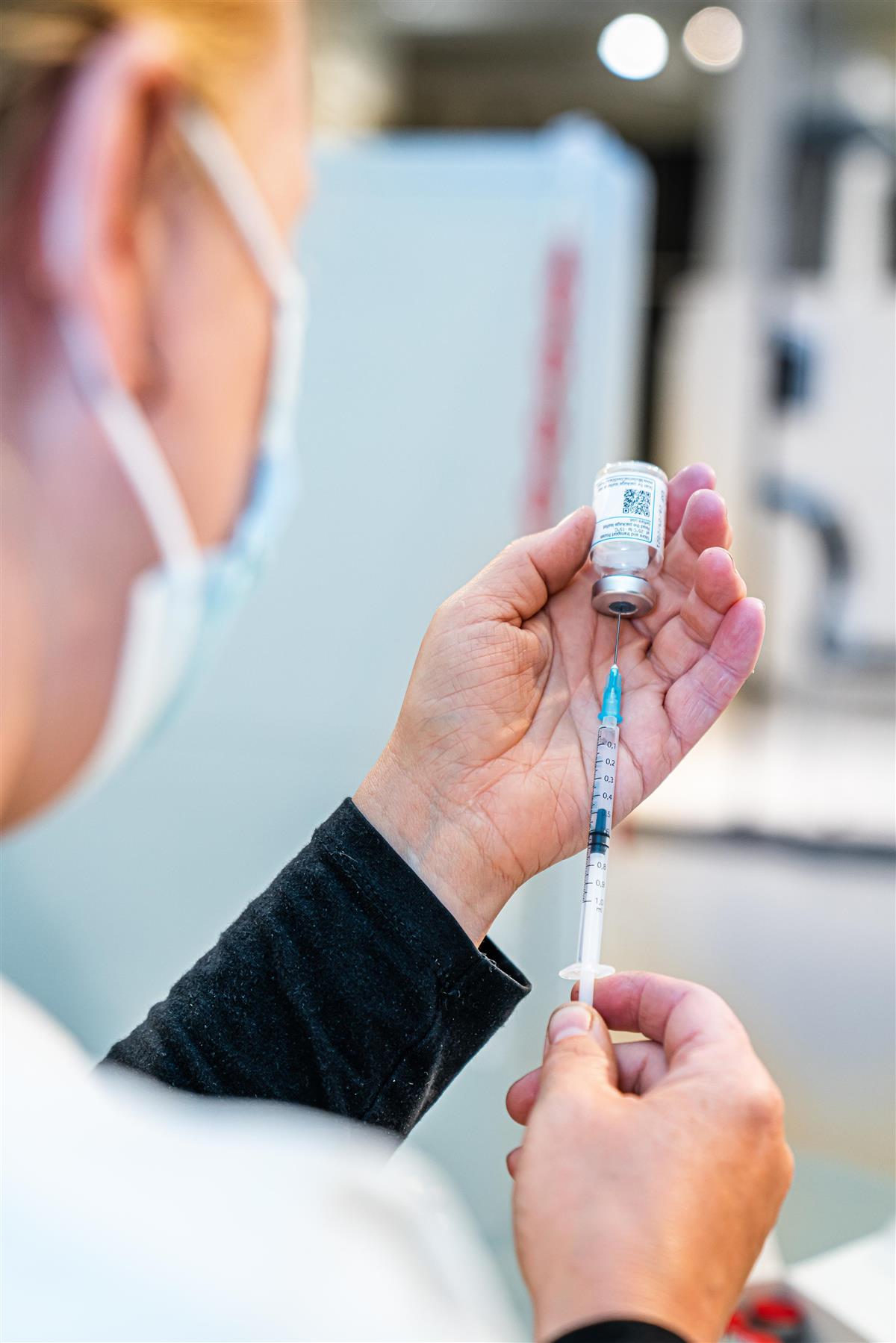 Sykepleier måler opp vaksinedose - Klikk for stort bilde