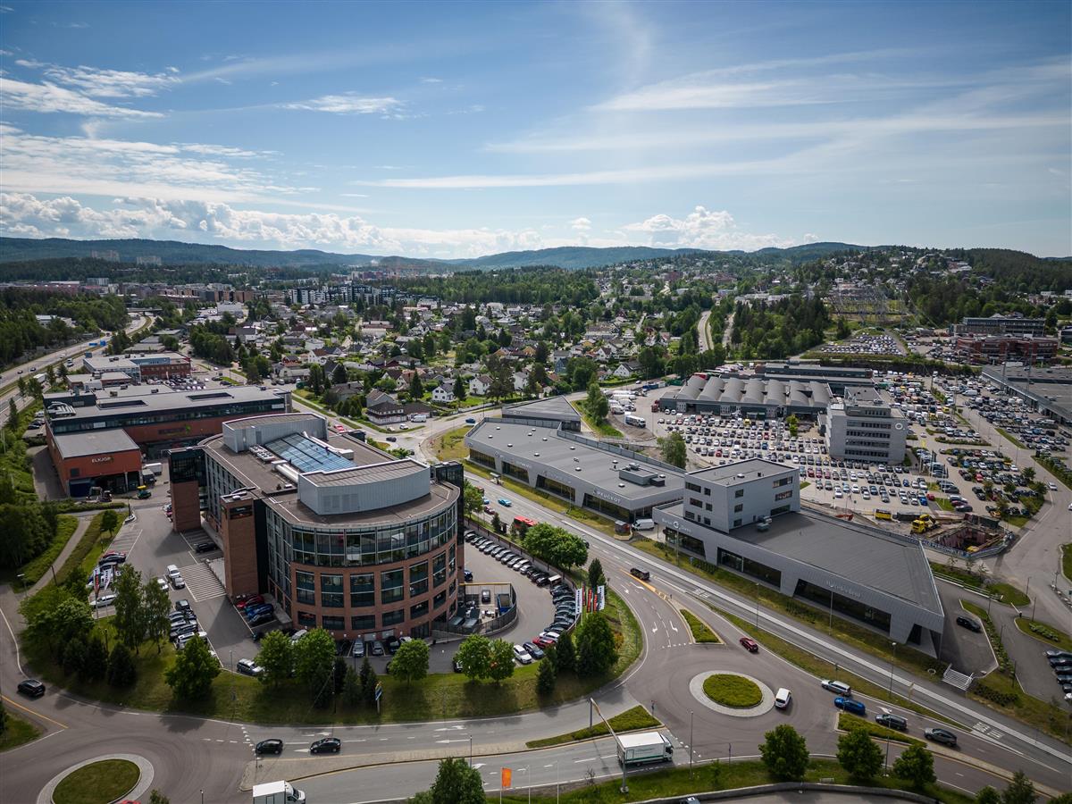 Dronebilde av næringsbygg og eneboliger på Visperud - Klikk for stort bilde