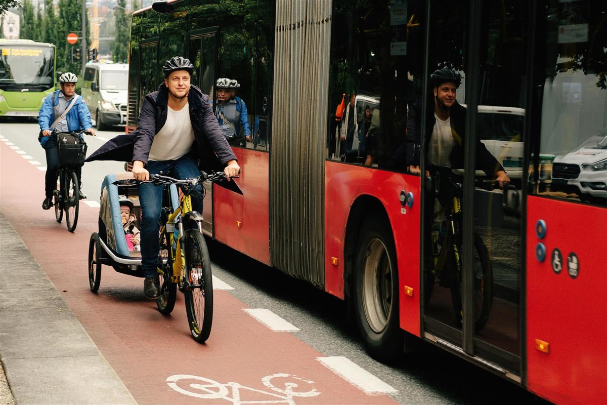 Syklister på sykkelvei ved siden av buss - Klikk for stort bilde