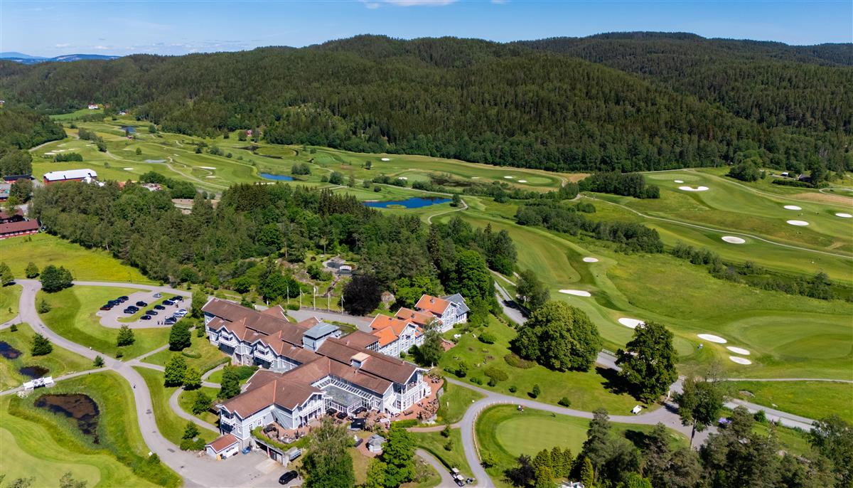 Dronebilde av Losby bruk omgitt av golfbanen og skog - Klikk for stort bilde