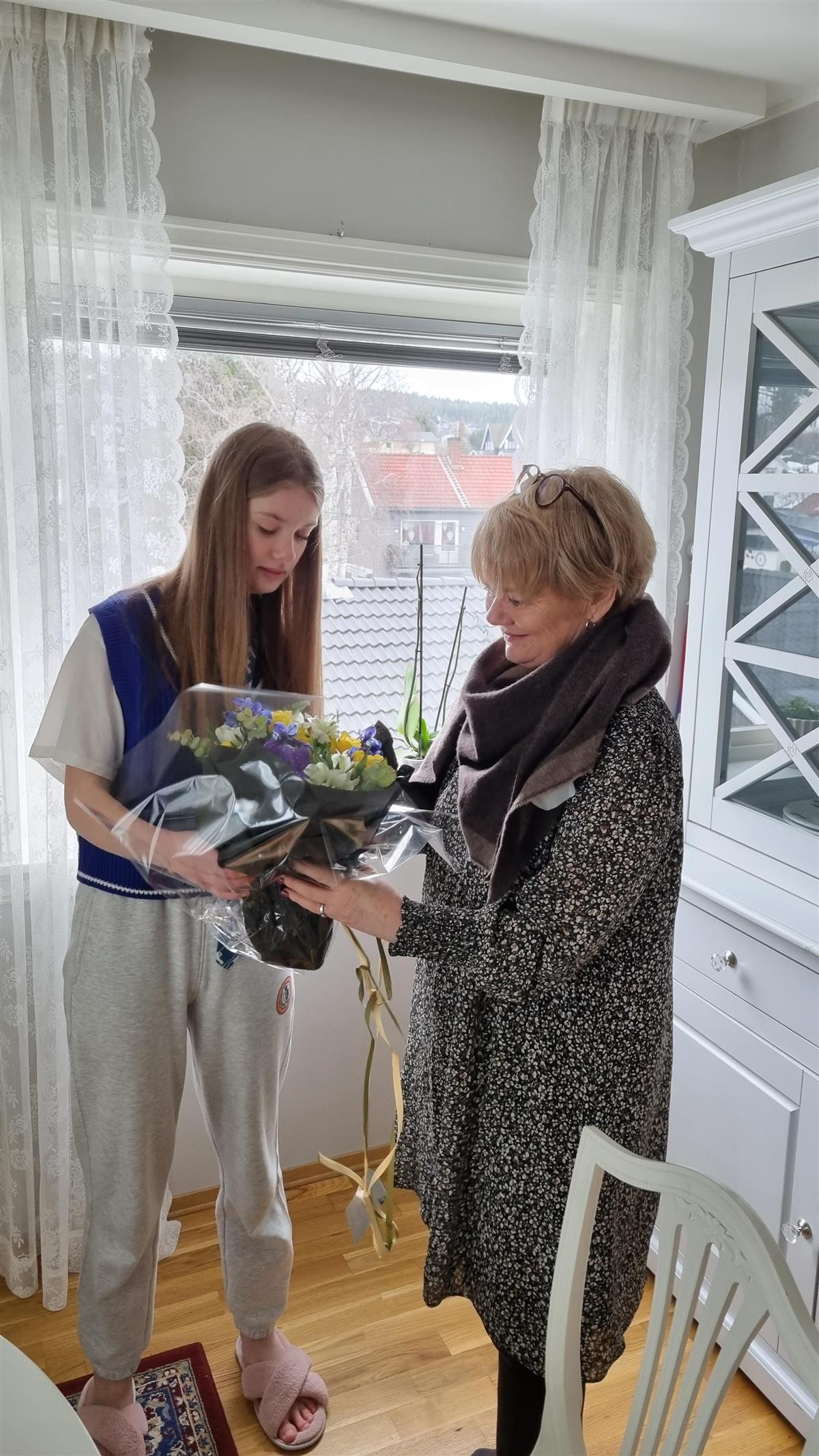Sofiia Mykhalevych pakker ut blomster i fargene til det ukrainske flagget som ordfører Ragnhild Bergheim hadde med til besøket. - Klikk for stort bilde