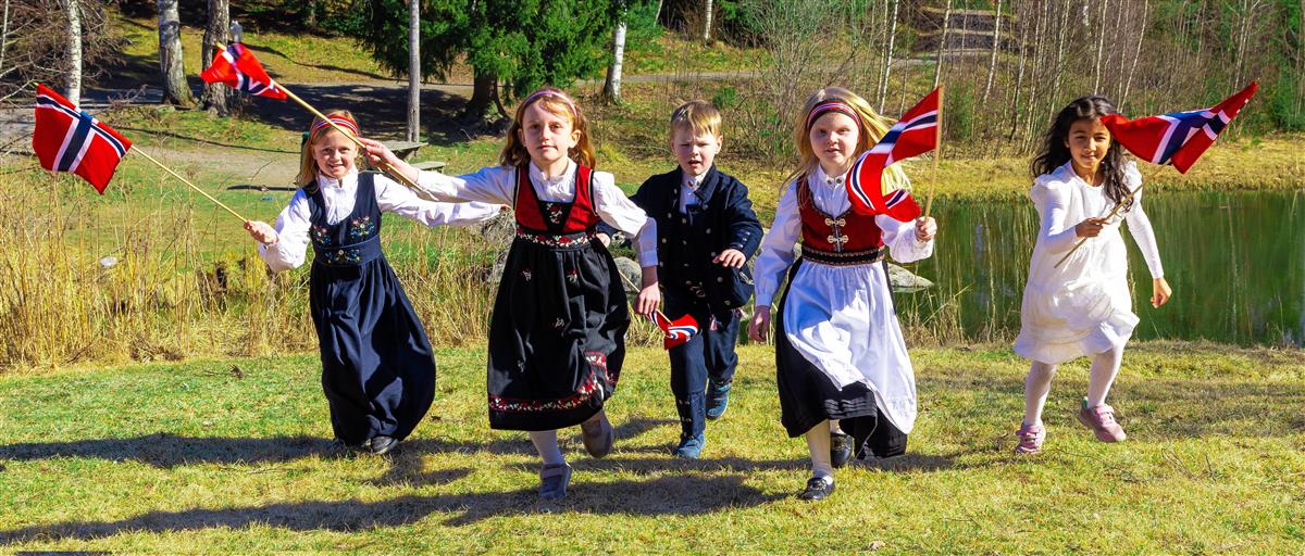 Barn med flagg og festklær løper mor fotografen - Klikk for stort bilde