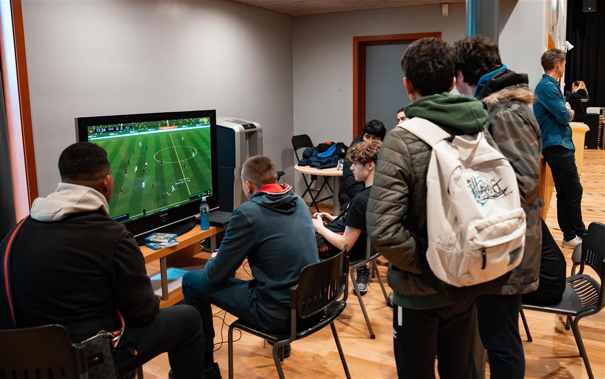 Ungdommer spiller foran en TV-skjerm - Klikk for stort bilde