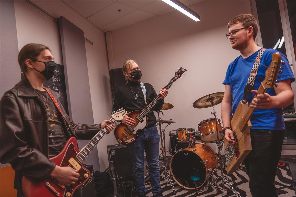 Tre menn med gitater i et øvingslokale for band - Klikk for stort bilde