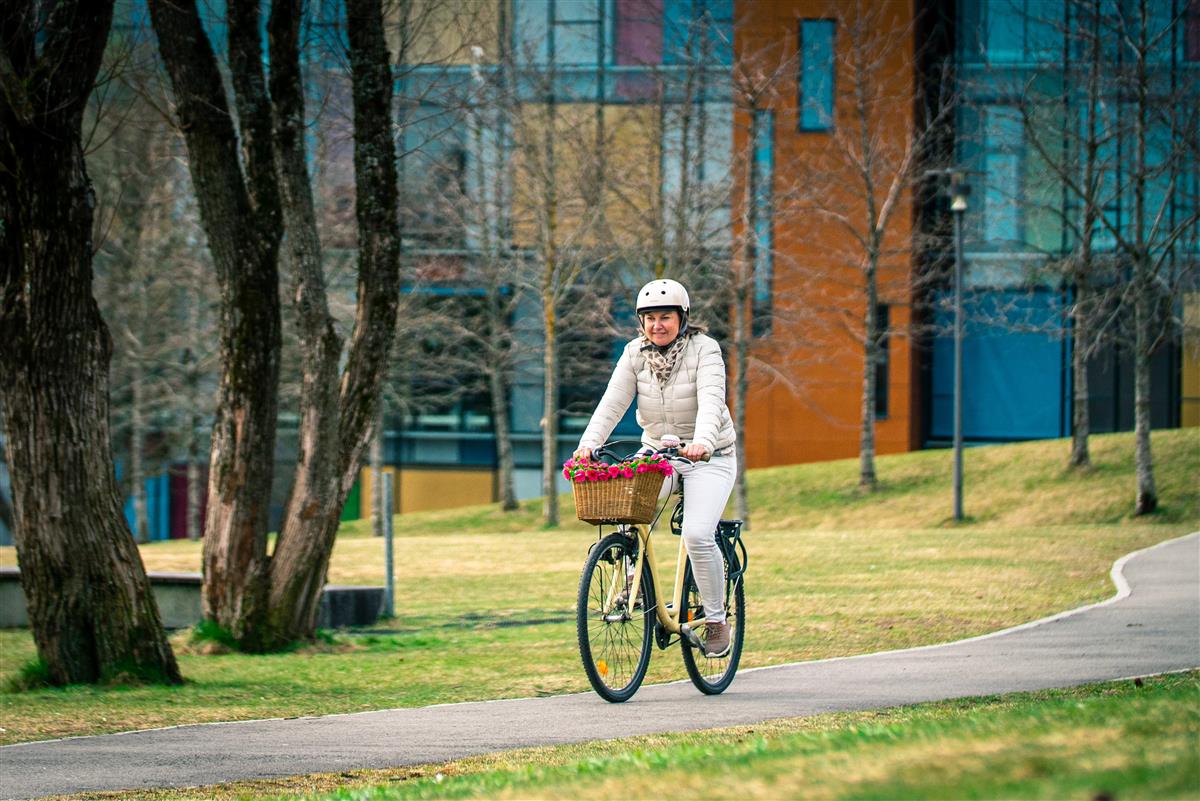 Kvinne som sykler på gangvei i park - Klikk for stort bilde