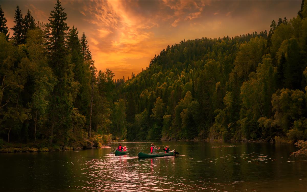 Kanotur på vann i solnedgang - Klikk for stort bilde