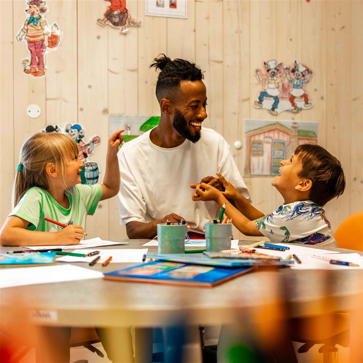 Voksen barnehageansatt leker med to barn - Klikk for stort bilde